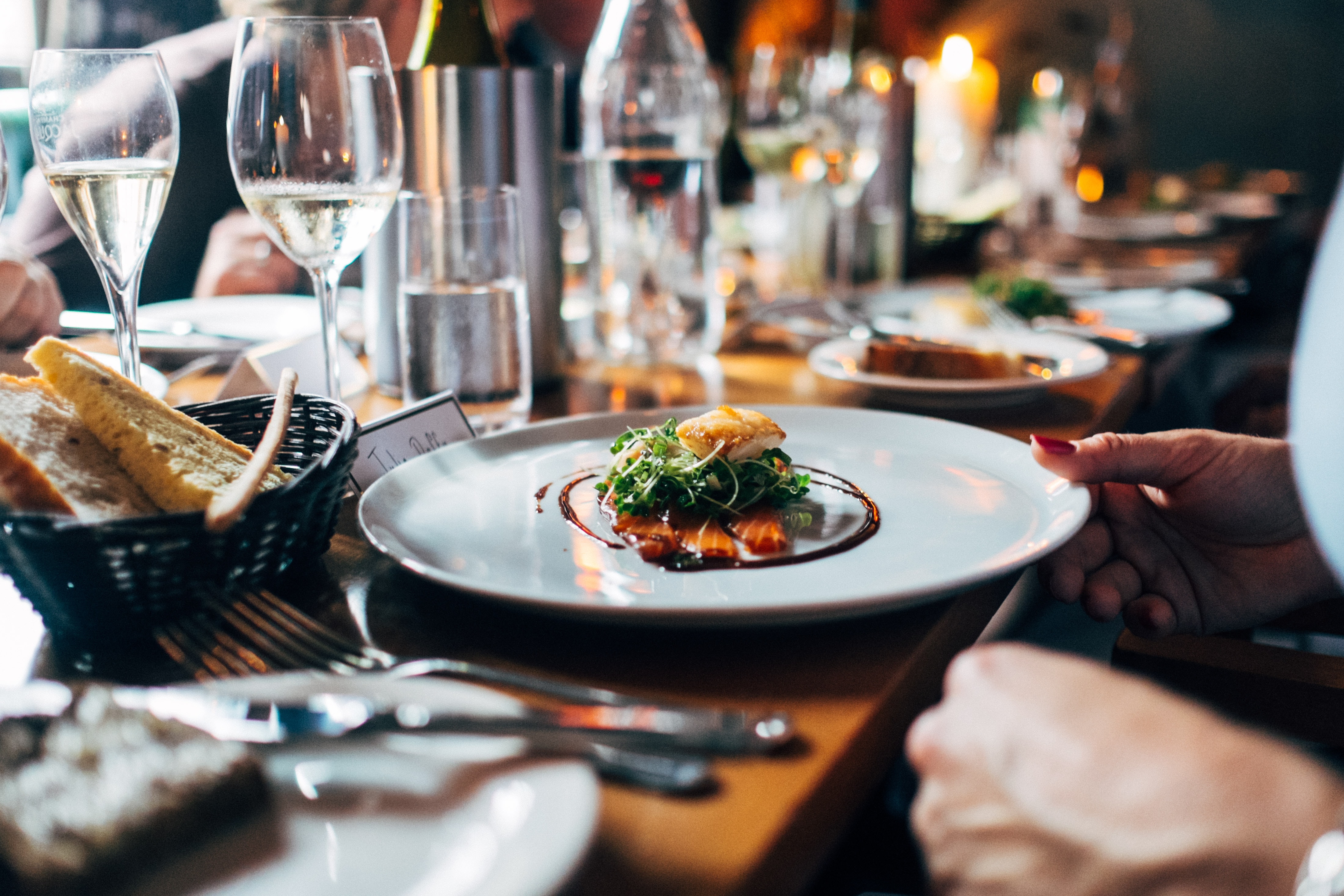 food centered on white plate next to bread basket
